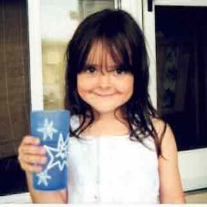 small girl with blue cup and goofy smile