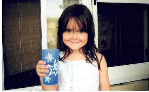 small girl with blue cup and goofy smile