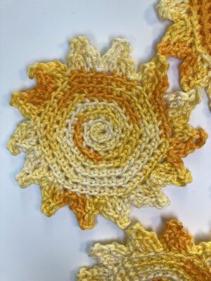 sun coasters in yellow variegated yarn